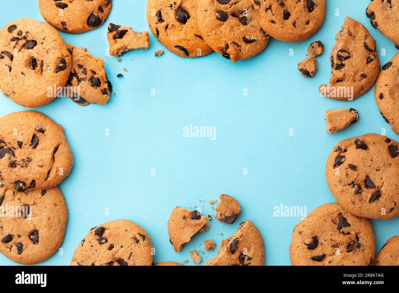 Frame made of many delicious chocolate chip cookies on light blue background, flat lay. Space for text Stock Photo