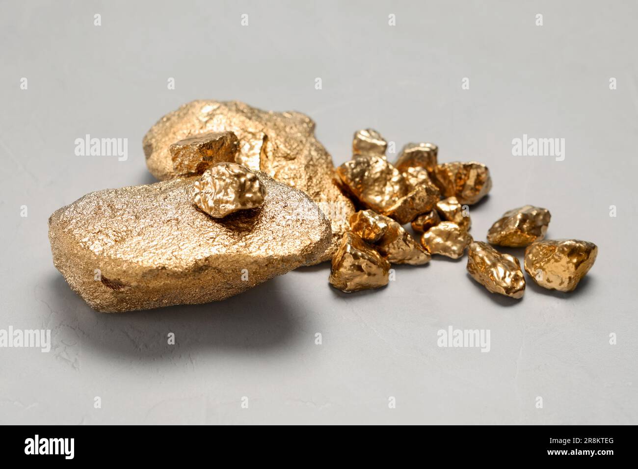 Pile of gold nuggets on light grey table Stock Photo - Alamy
