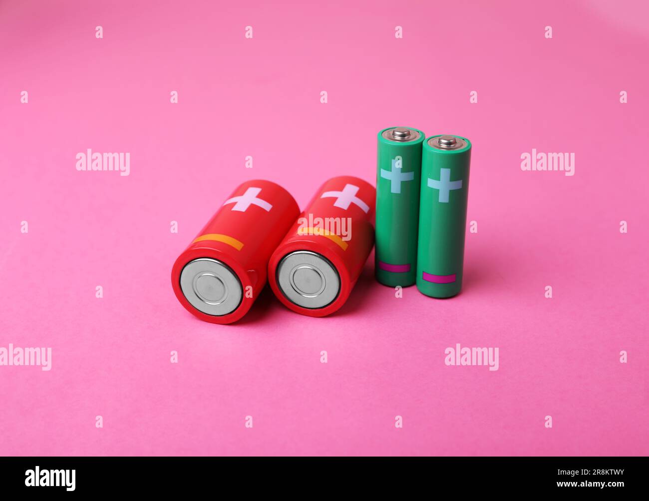 New AA and C sizes batteries on pink background Stock Photo Alamy