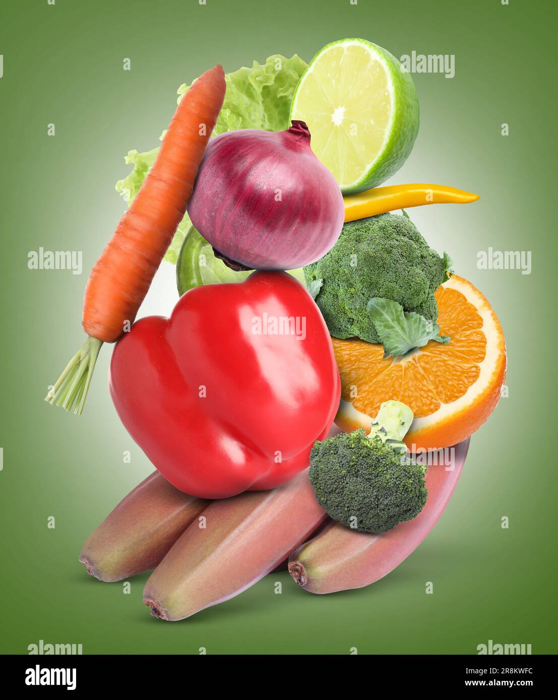 Stack of different vegetables and fruits on pale green background Stock Photo