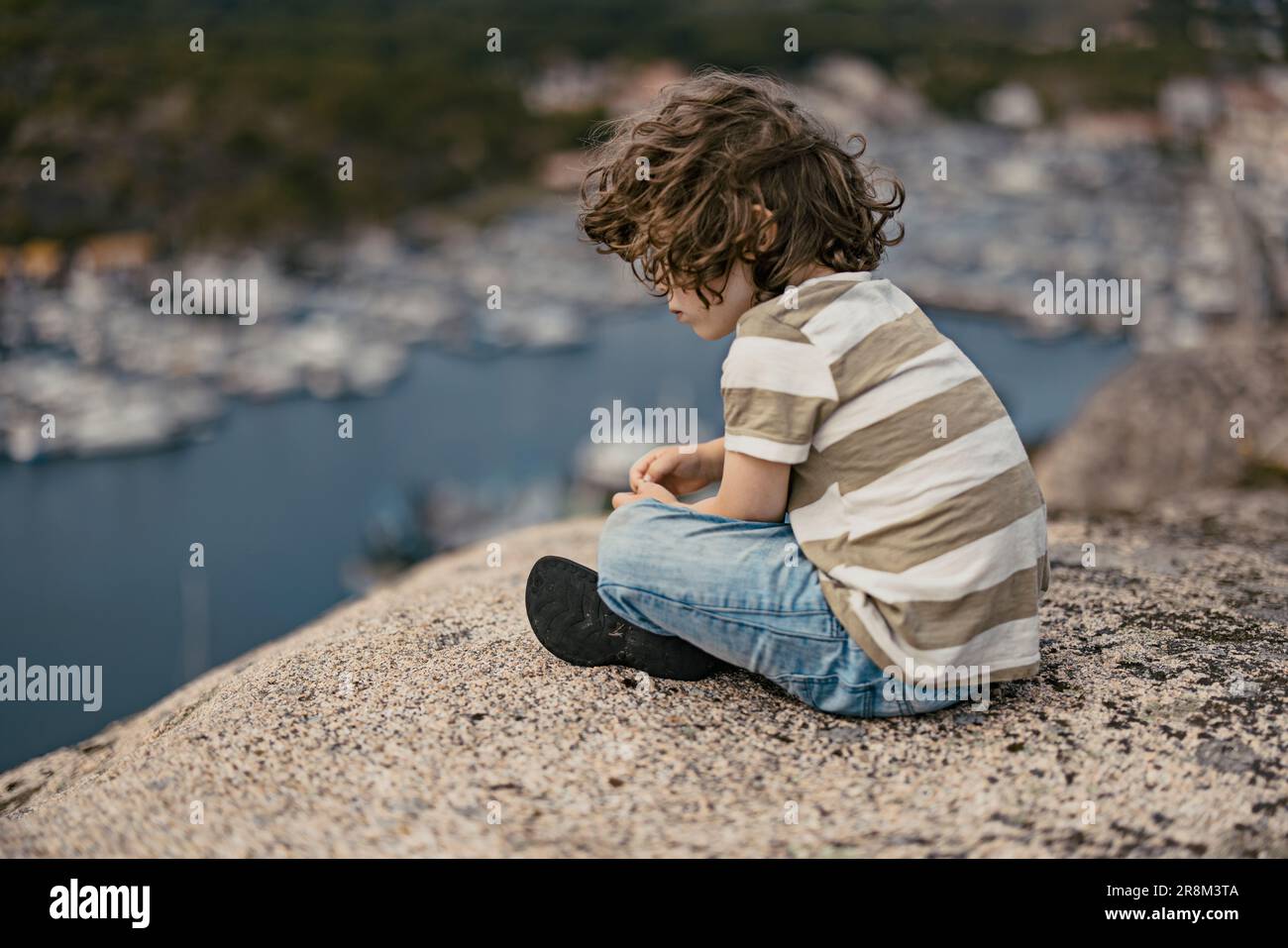 Boy sitting and looking at sea Stock Photo
