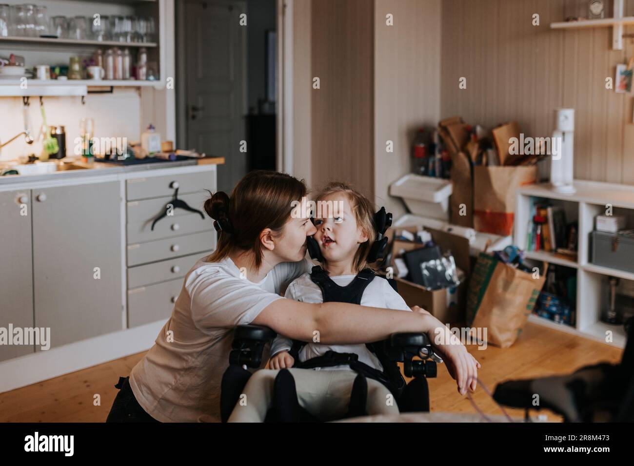 Mother taking care of disabled child in wheelchair at home Stock Photo Alamy