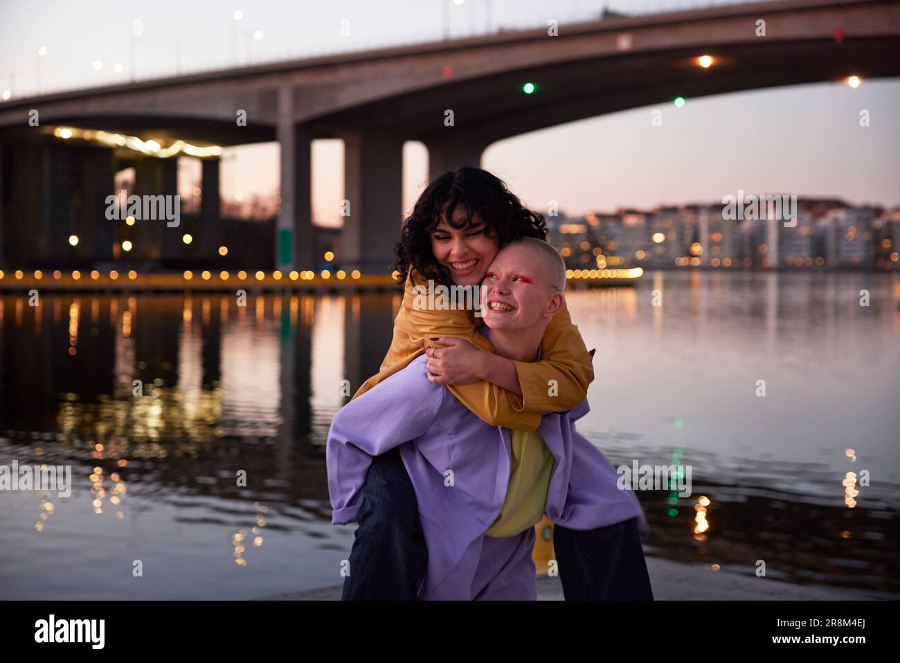 Young woman giving friend or girlfriend piggyback ride Stock Photo