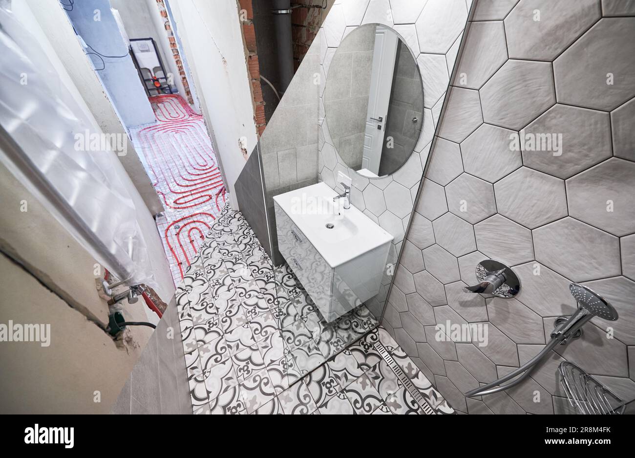 Photo collage of apartment bathroom before and after restoration. Comparison of old room with underfloor heating pipes and new renovated restroom with sink, shower, mirror and towel dryer. Stock Photo