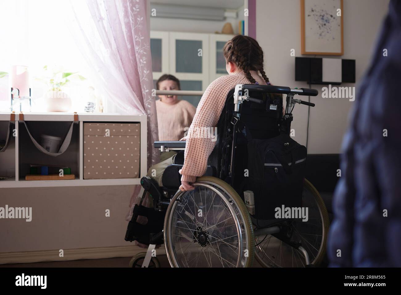 Teenage disabled girl on wheelchair in front of mirror Stock Photo