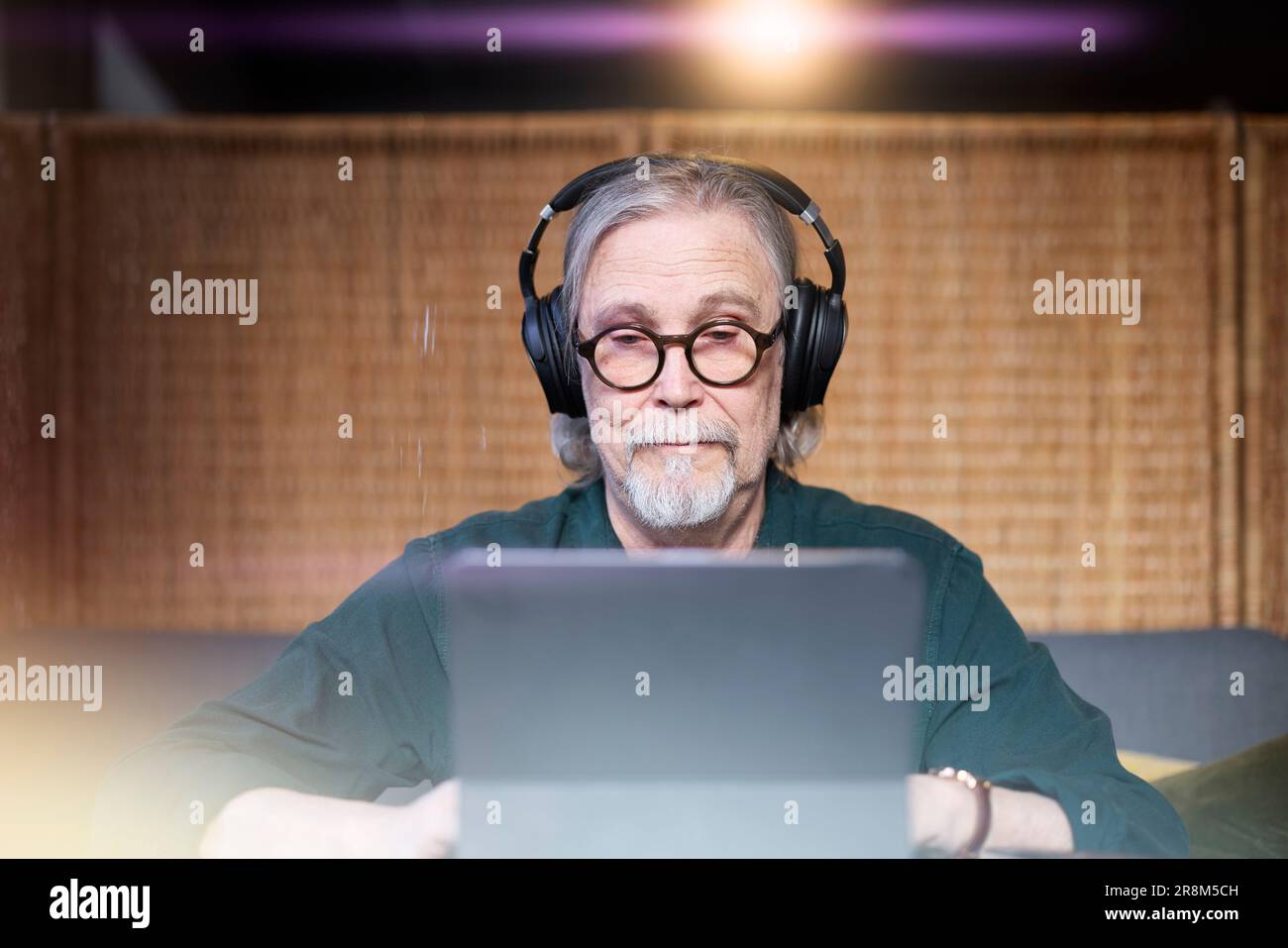 Senior man with headphones using tablet Stock Photo