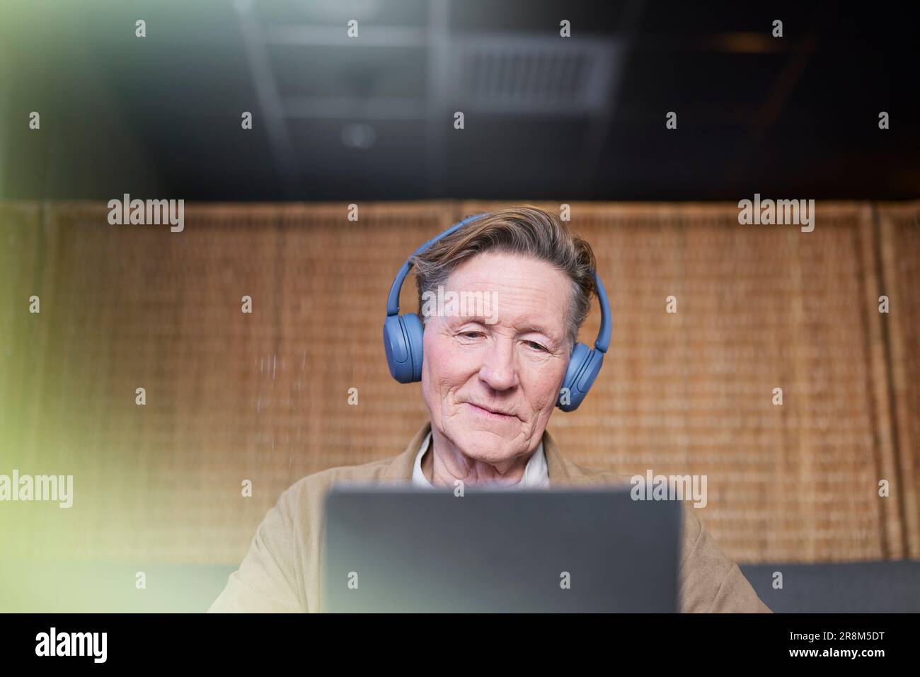 Senior man with headphones using tablet Stock Photo