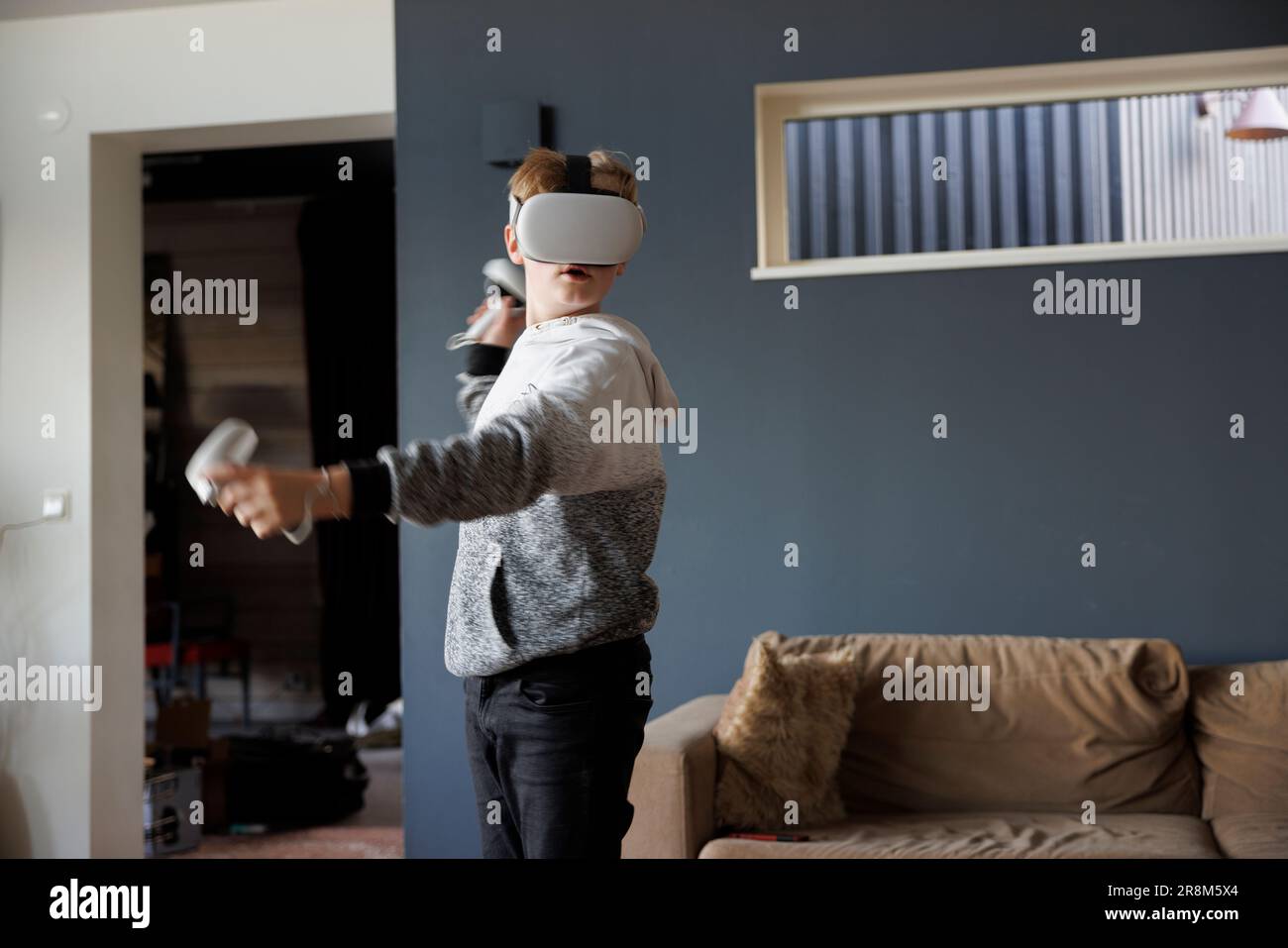 Boy wearing virtual reality goggles during VR experience Stock Photo