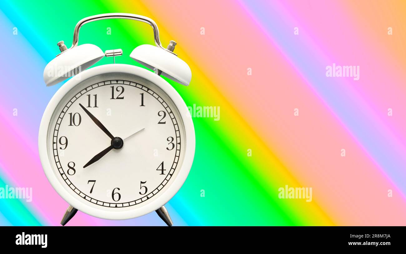 white retro alarm clock on a colorful backdrop Stock Photo