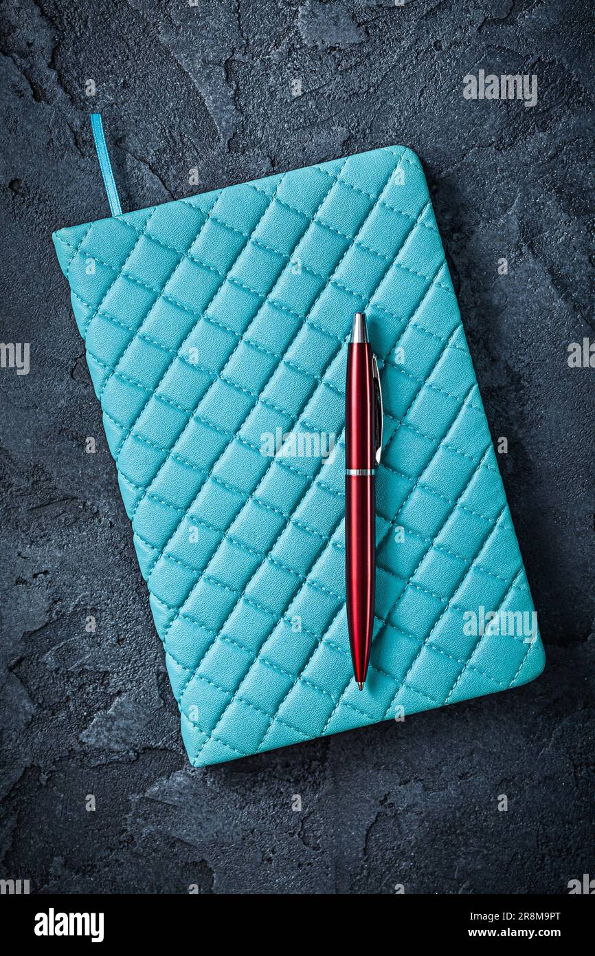 Blue Notepad And Red Ballpoint Pen On Black Background Stock Photo