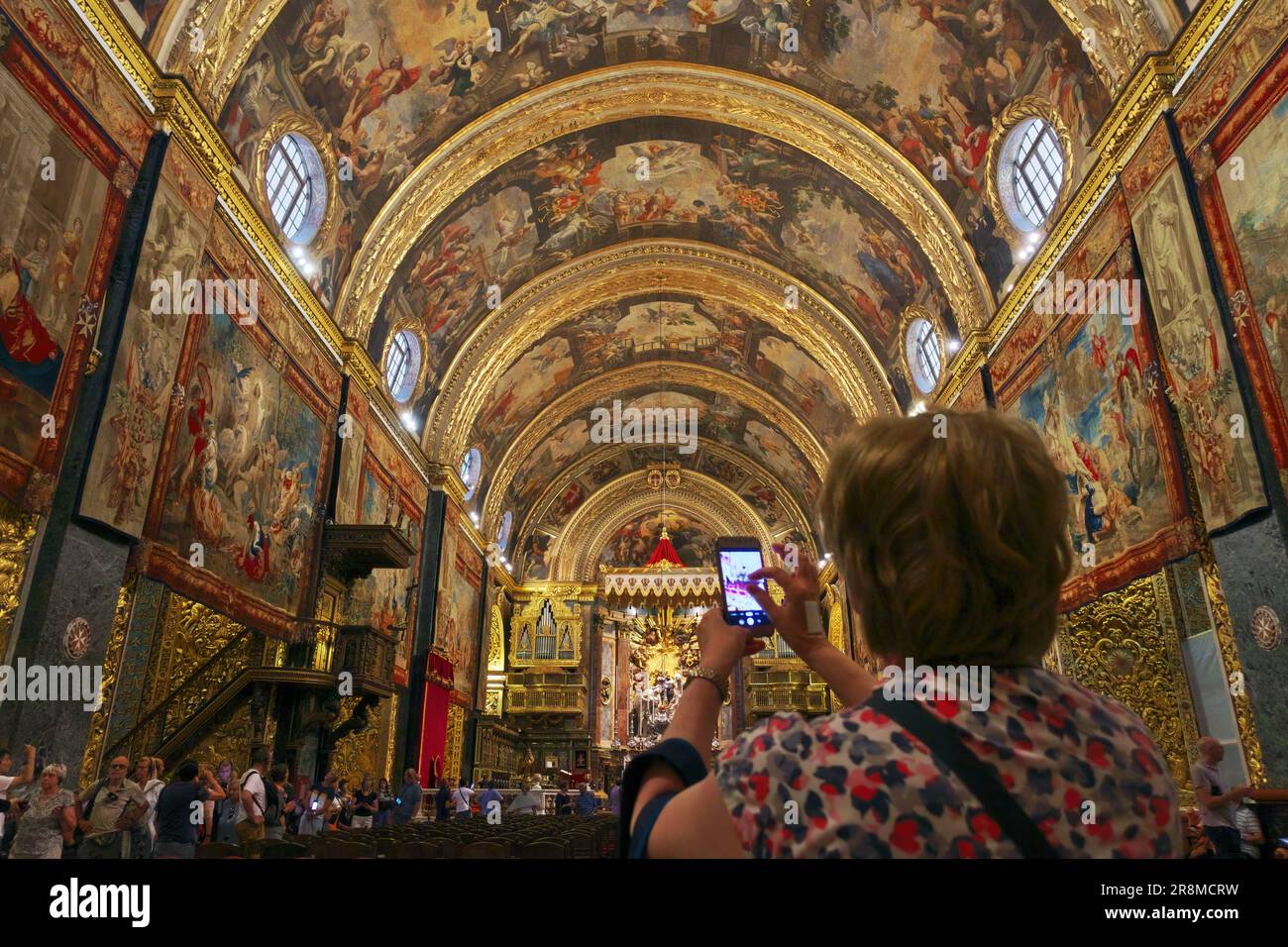woman taking a photo inside St John's Co-Cathedral in Valletta, Malta Stock Photo