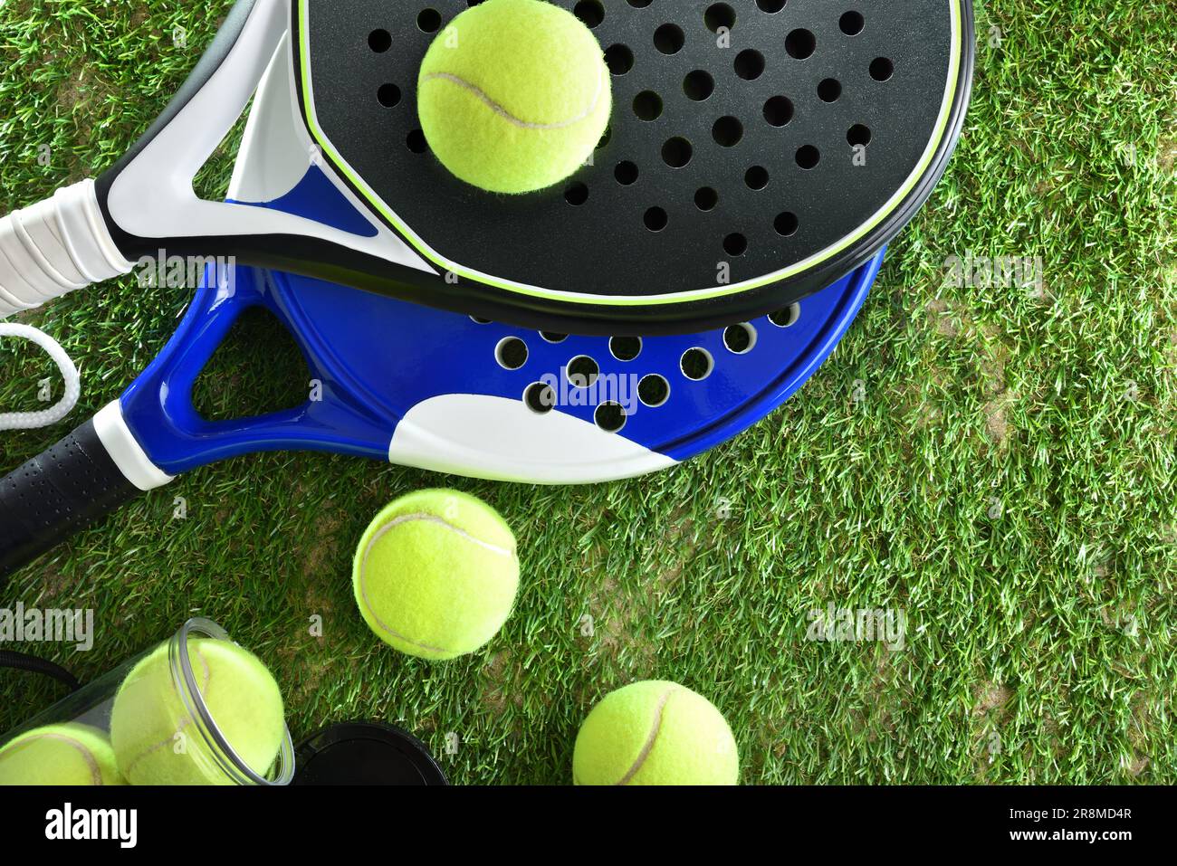 Two paddle tennis rackets and a can of balls on artificial grass. Top view. Stock Photo