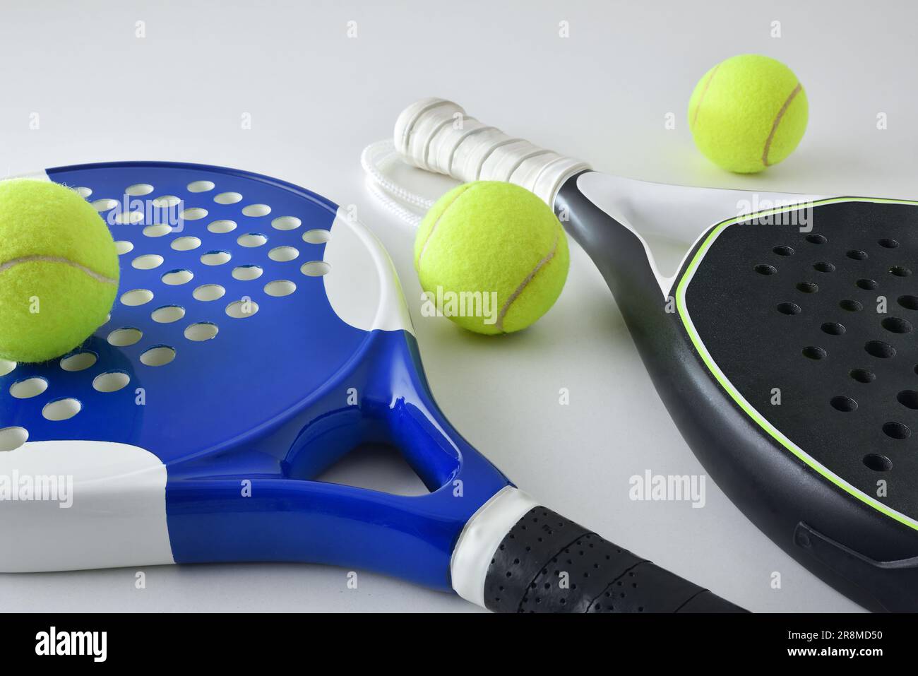 Background with two blue and black paddle rackets on a white table with balls. Elevated view. Stock Photo