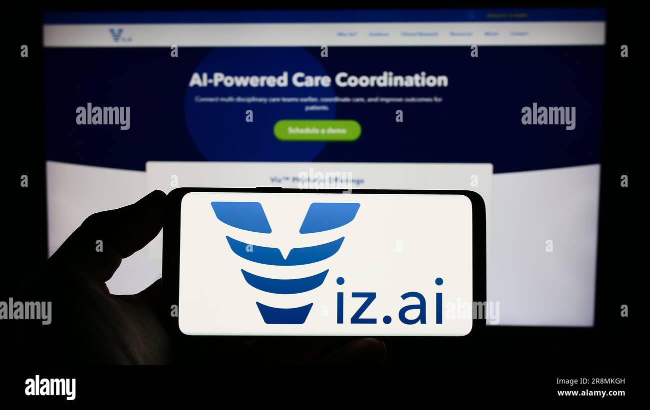 Person holding smartphone with logo of US artificial intelligence company Viz.ai Inc. on screen in front of website. Focus on phone display. Stock Photo