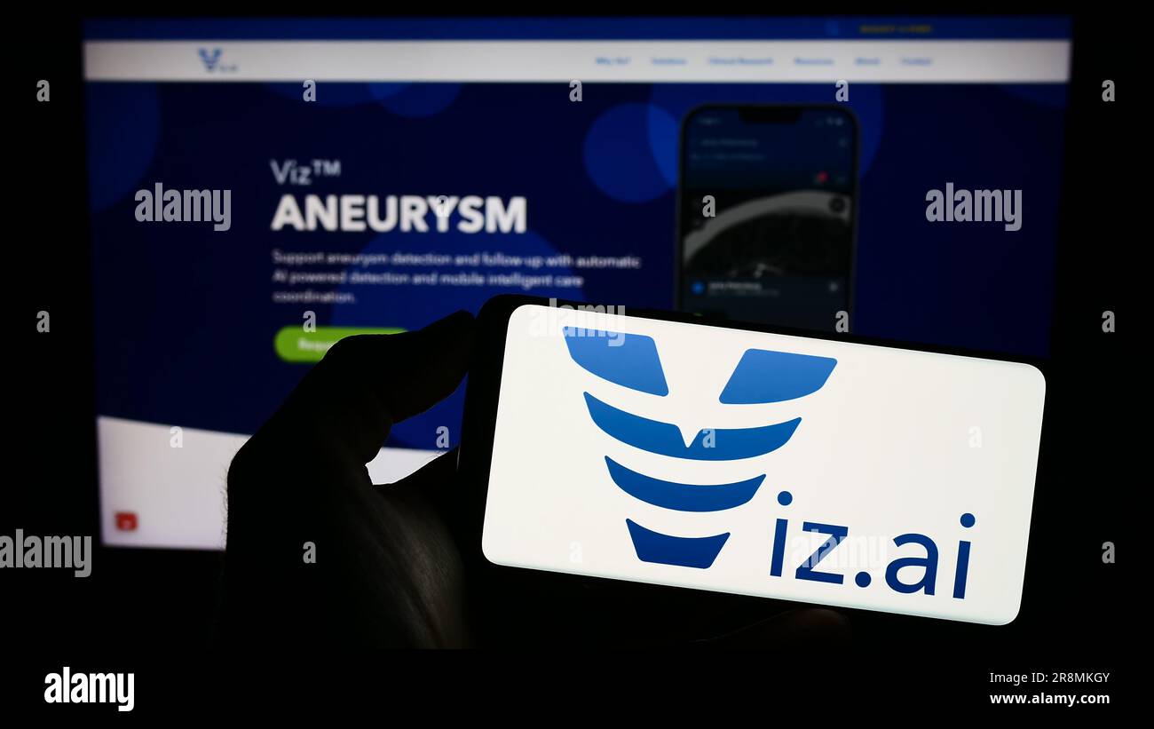 Person holding mobile phone with logo of US artificial intelligence company Viz.ai Inc. on screen in front of web page. Focus on phone display. Stock Photo