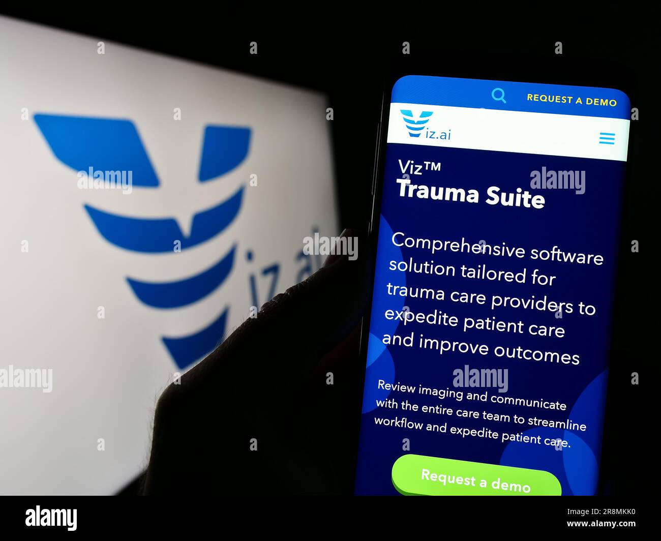 Person holding cellphone with webpage of US artificial intelligence company Viz.ai Inc. on screen with logo. Focus on center of phone display. Stock Photo