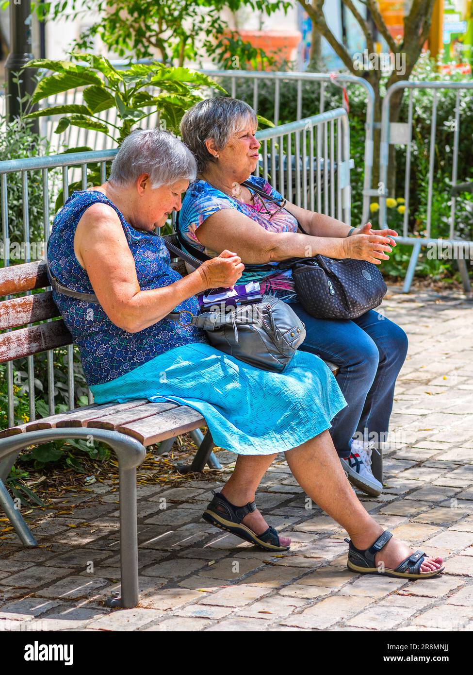 Two elderly women chatting on garden seat in city center - Tours, Indre-et-Loire (37), France. Stock Photo