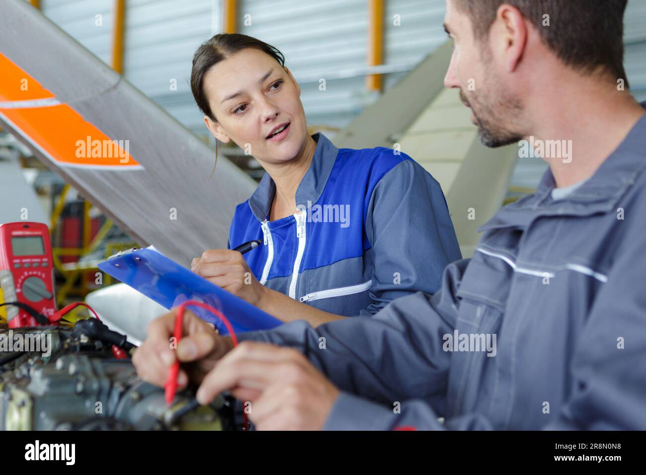 aero engineer and apprentice working in hangar Stock Photo - Alamy
