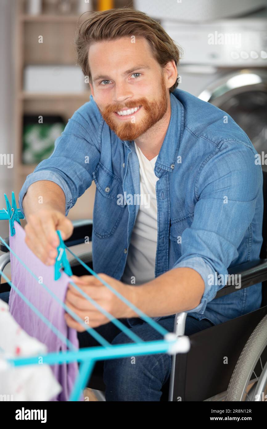 disabled man on wheelchair doing laundry Stock Photo