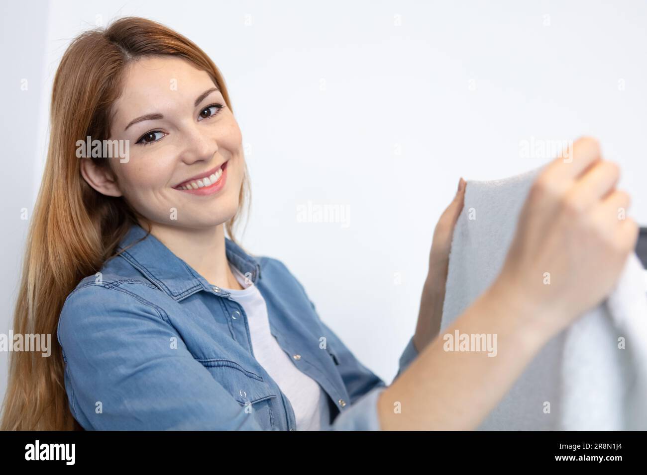 young woman looking at clothes after washing Stock Photo