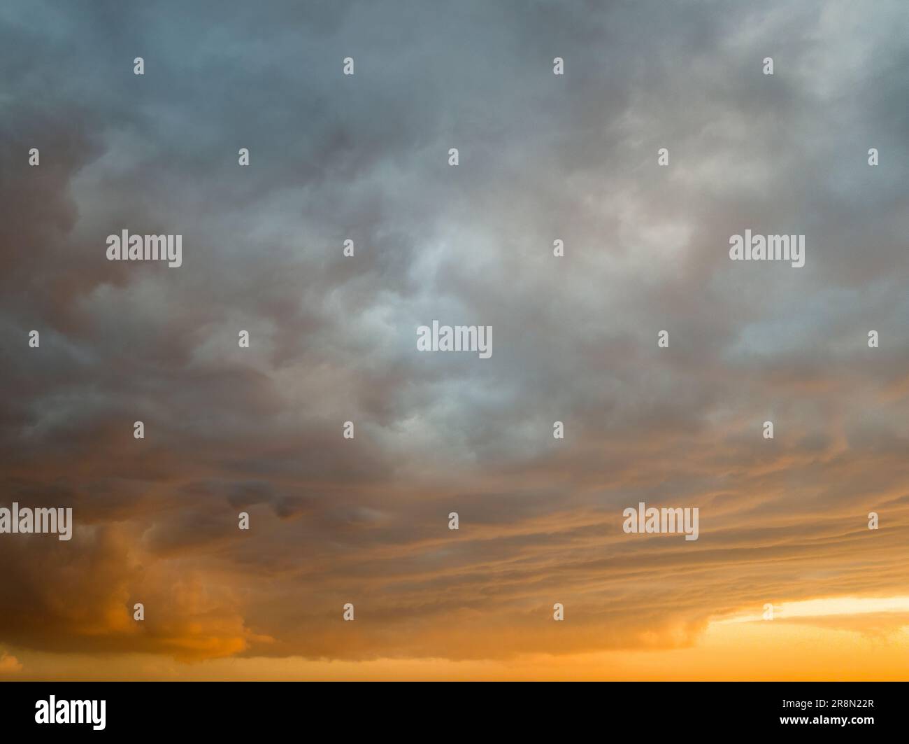 Orange dramatic cloudy sunset sky background overlay. Ideal for sky replacement, screen saver or any other application Stock Photo