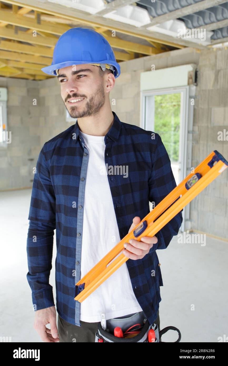 young handsome builder holding a spirit level Stock Photo