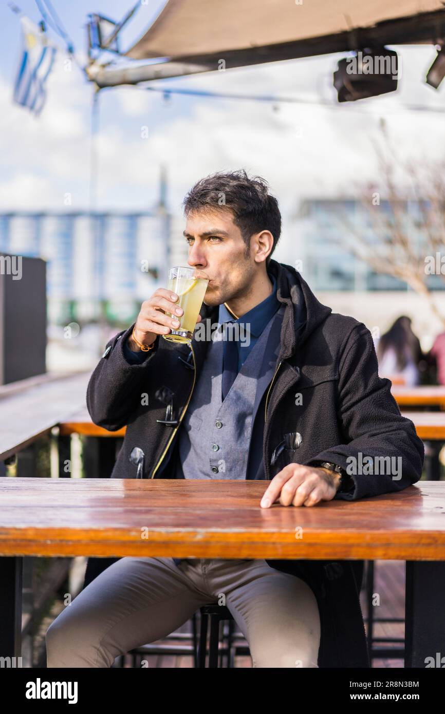 Man drinking a lemonade while sitting in a bar at the harbor Stock Photo