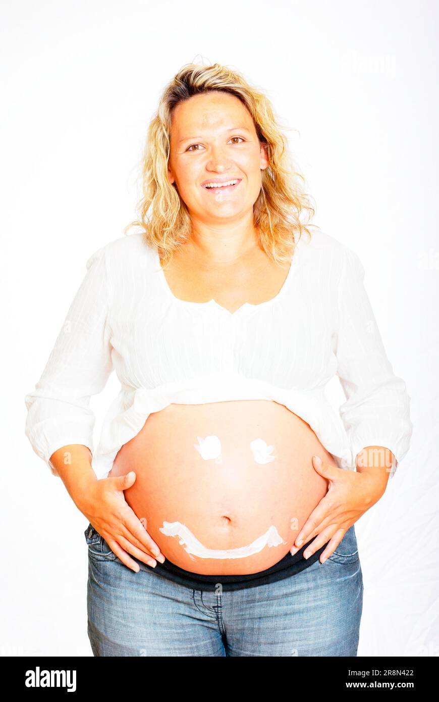 Pregnant woman with laughing face of cream on belly Stock Photo - Alamy