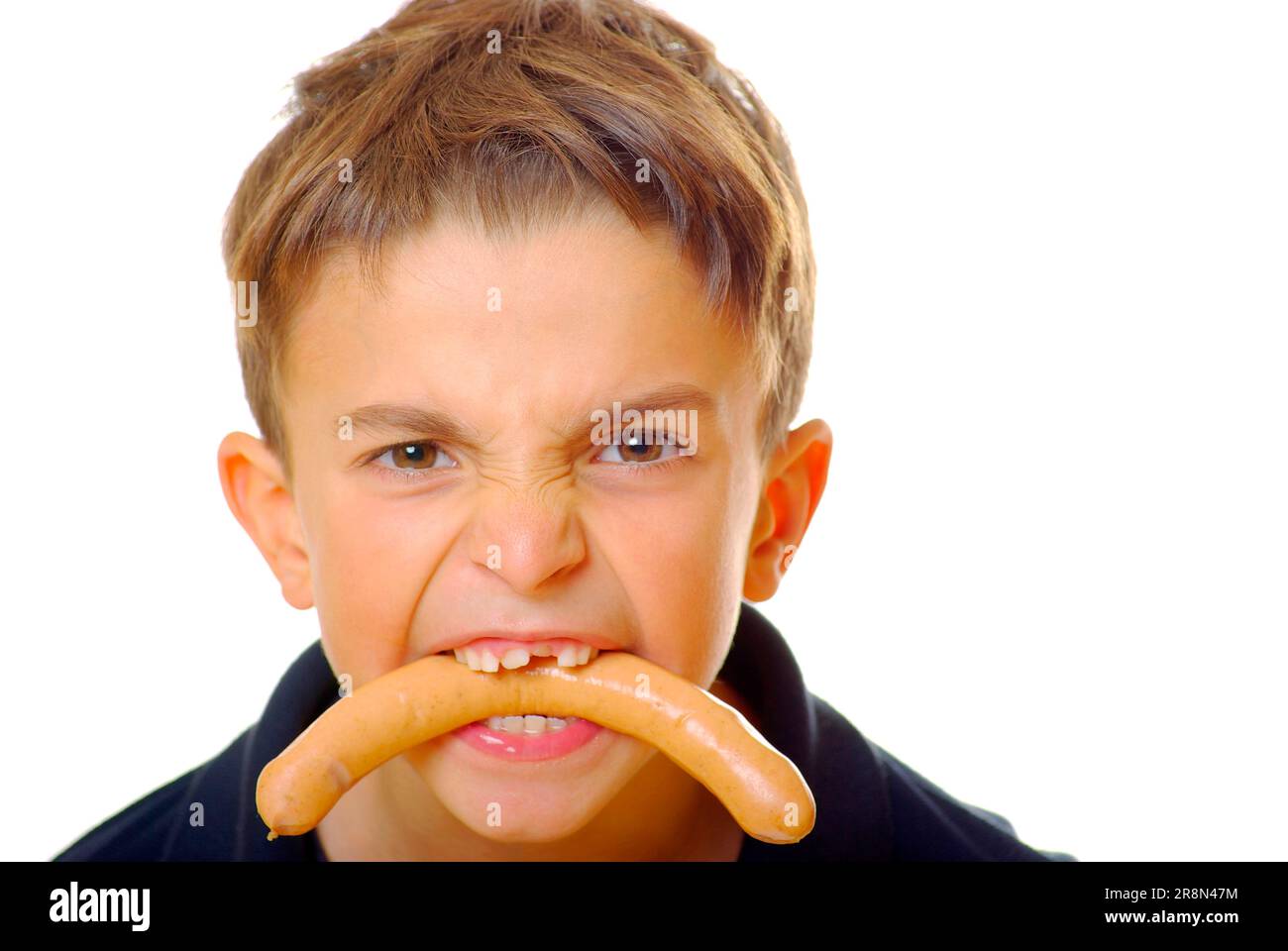 Boy with sausage in his mouth, gap between his teeth, sausage