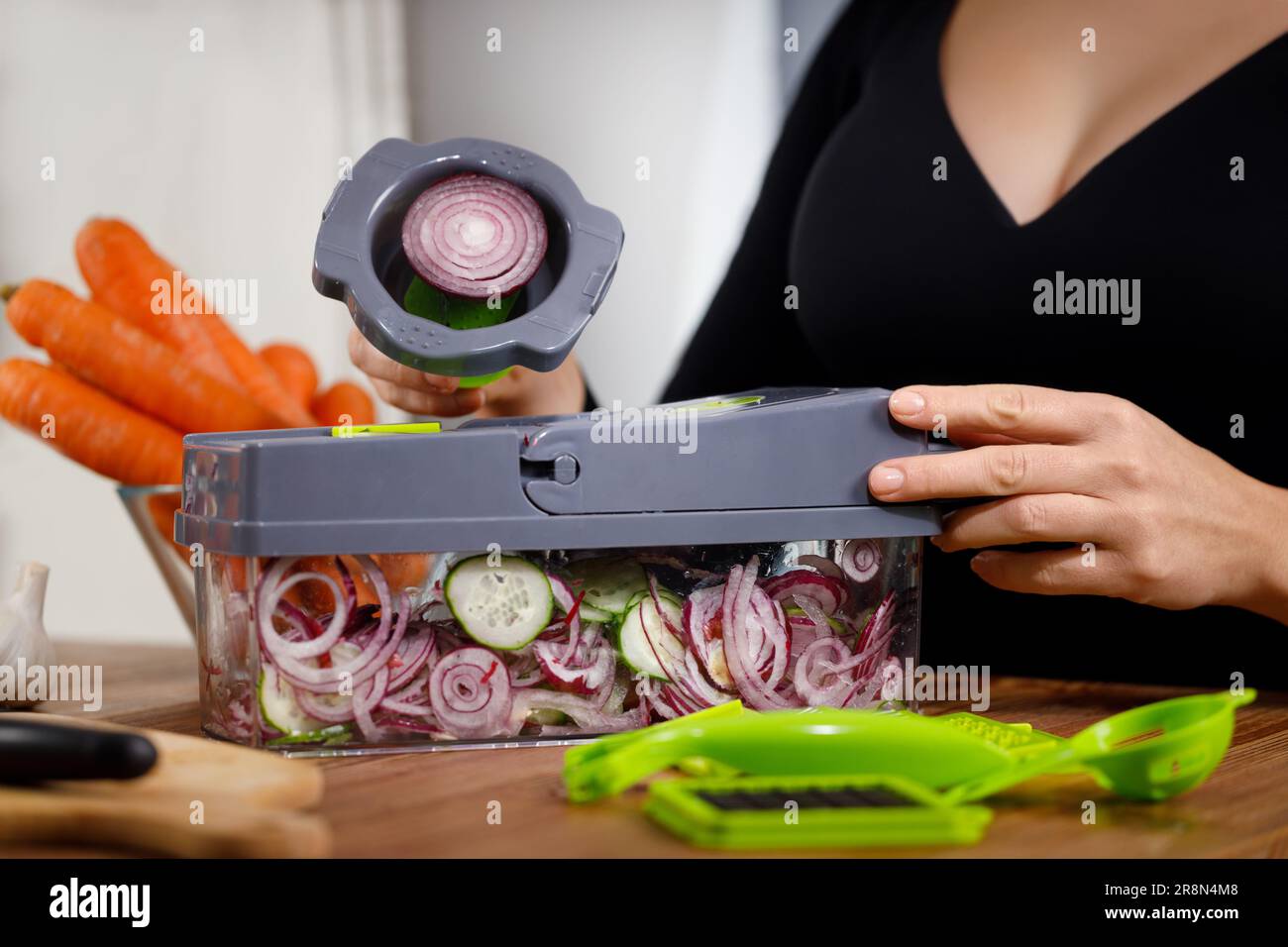 Woman in kitchen creating a salad meal, emphasizing a healthy lifestyle. Stock Photo