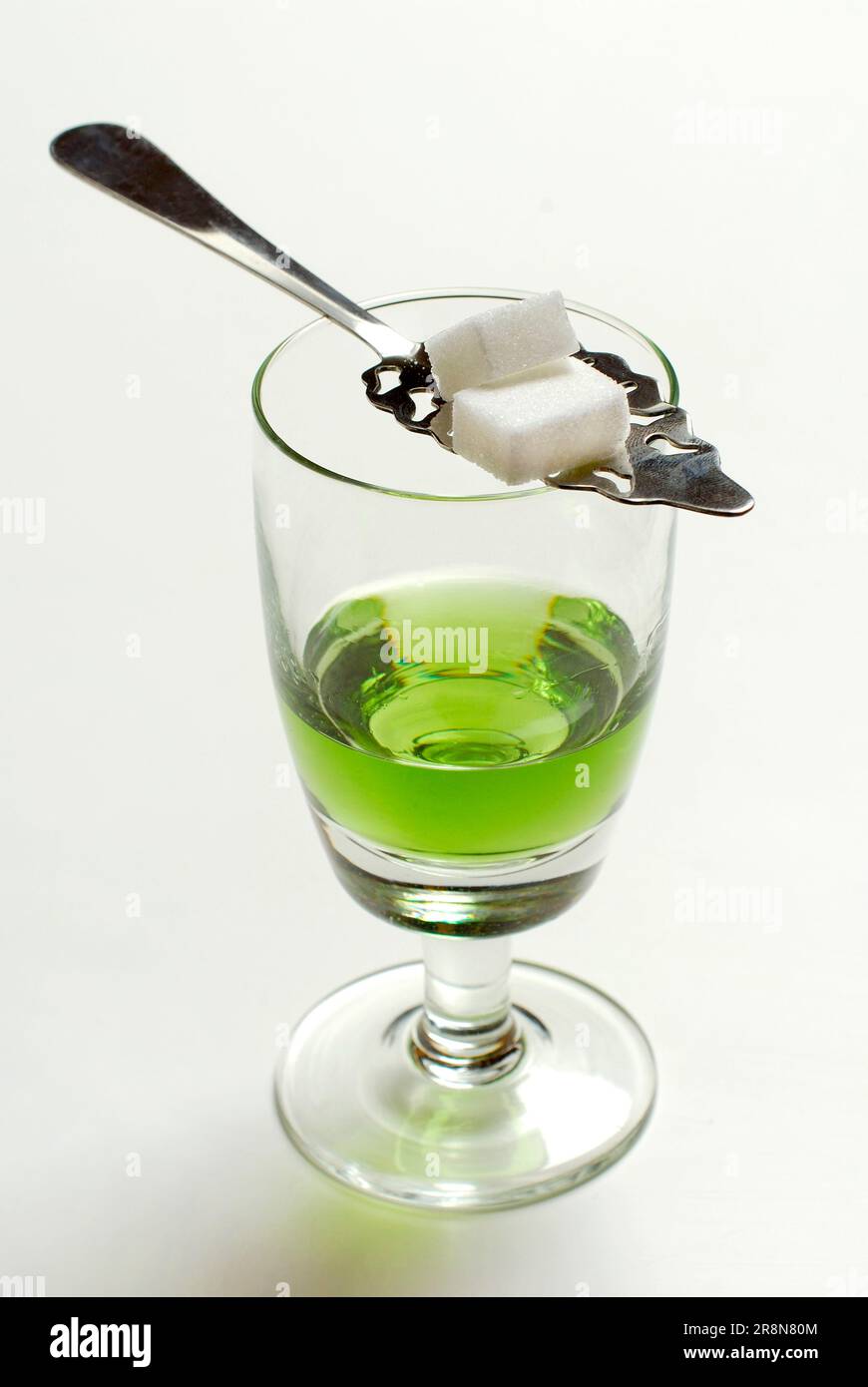 Glass of absinthe, sugar cube on absinthe spoon, green fairy, sugar