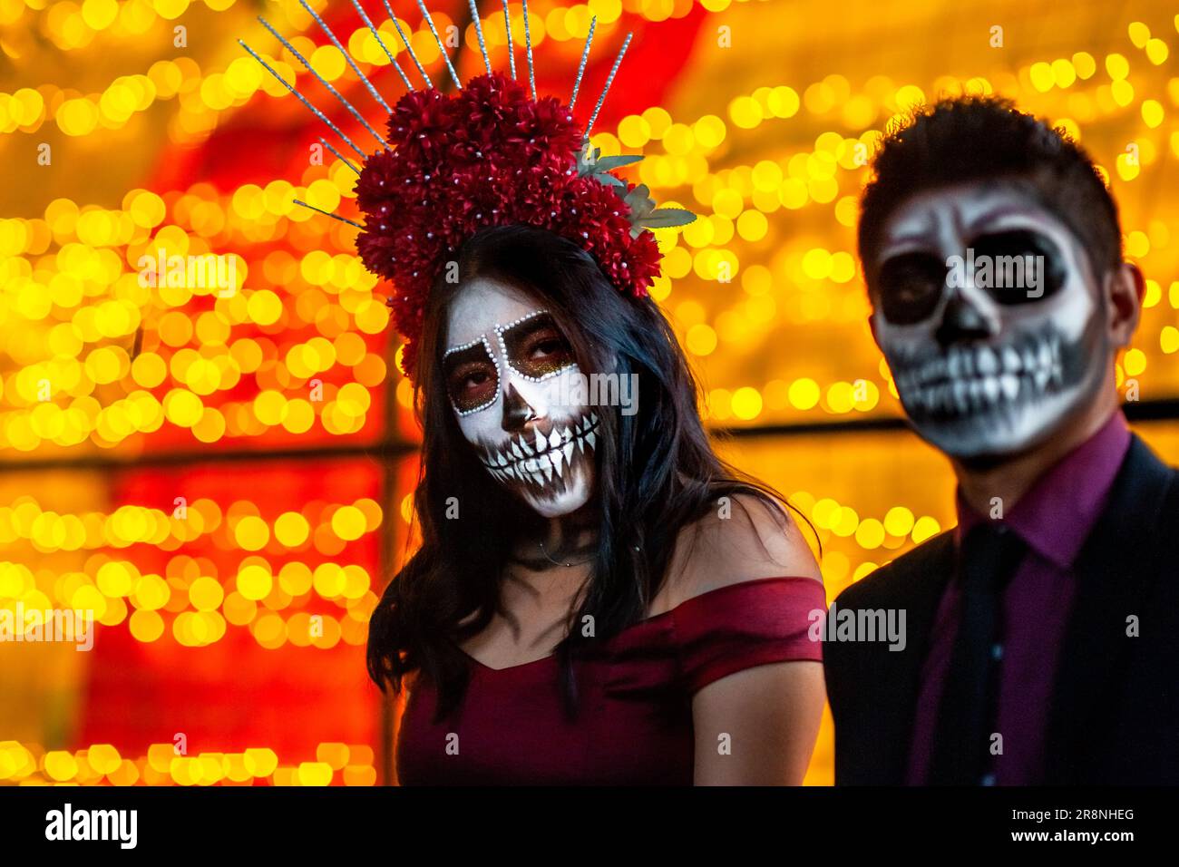 A Mexican woman, dressed as La Catrina, and a Mexican man, dressed as Catrín, take part in the Day of the Dead celebrations in Morelia, Mexico. Stock Photo
