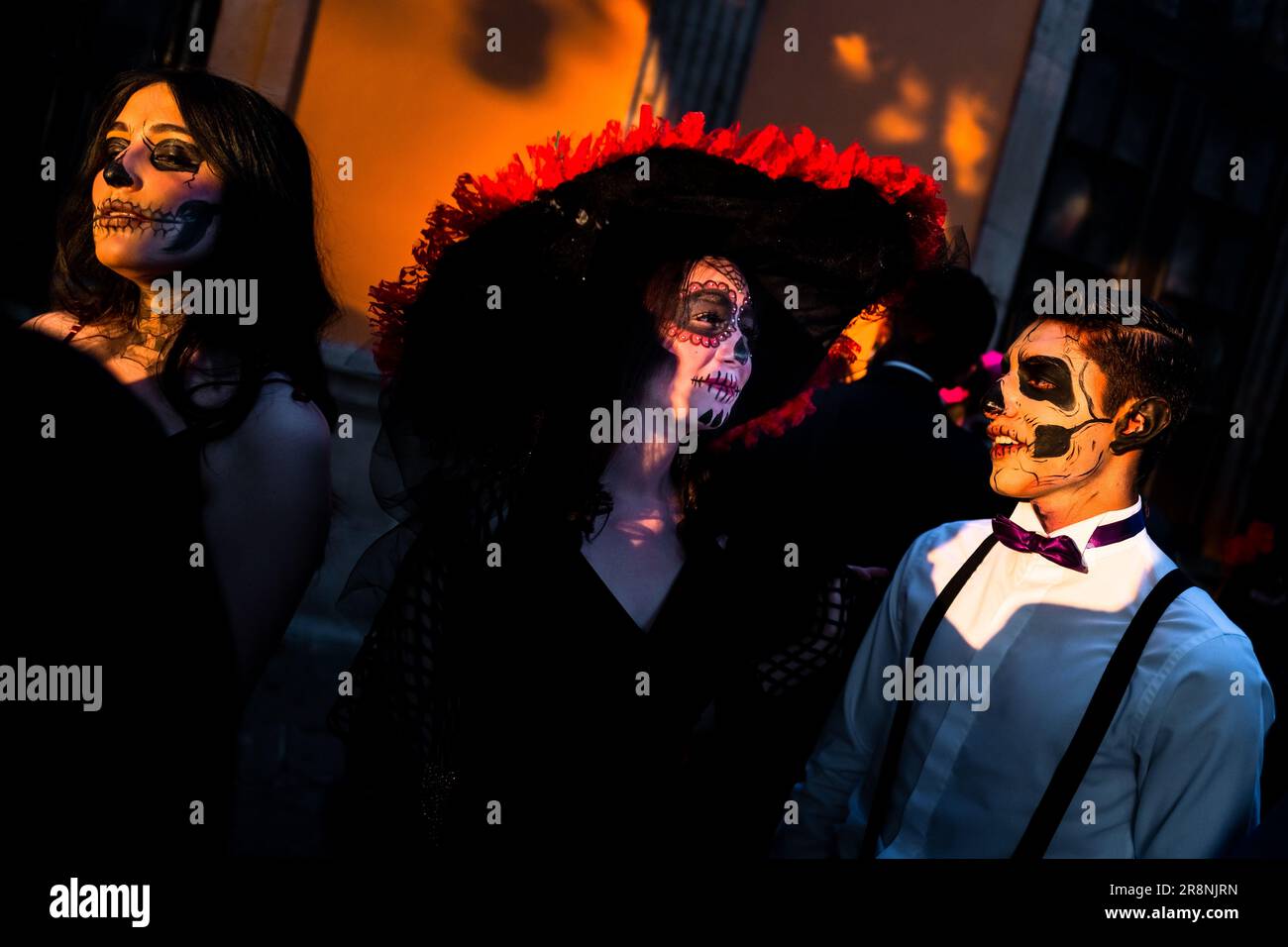 Mexican women, dressed as La Catrina, and a Mexican man, dressed as Catrín, take part in the Day of the Dead celebrations in Morelia, Mexico. Stock Photo