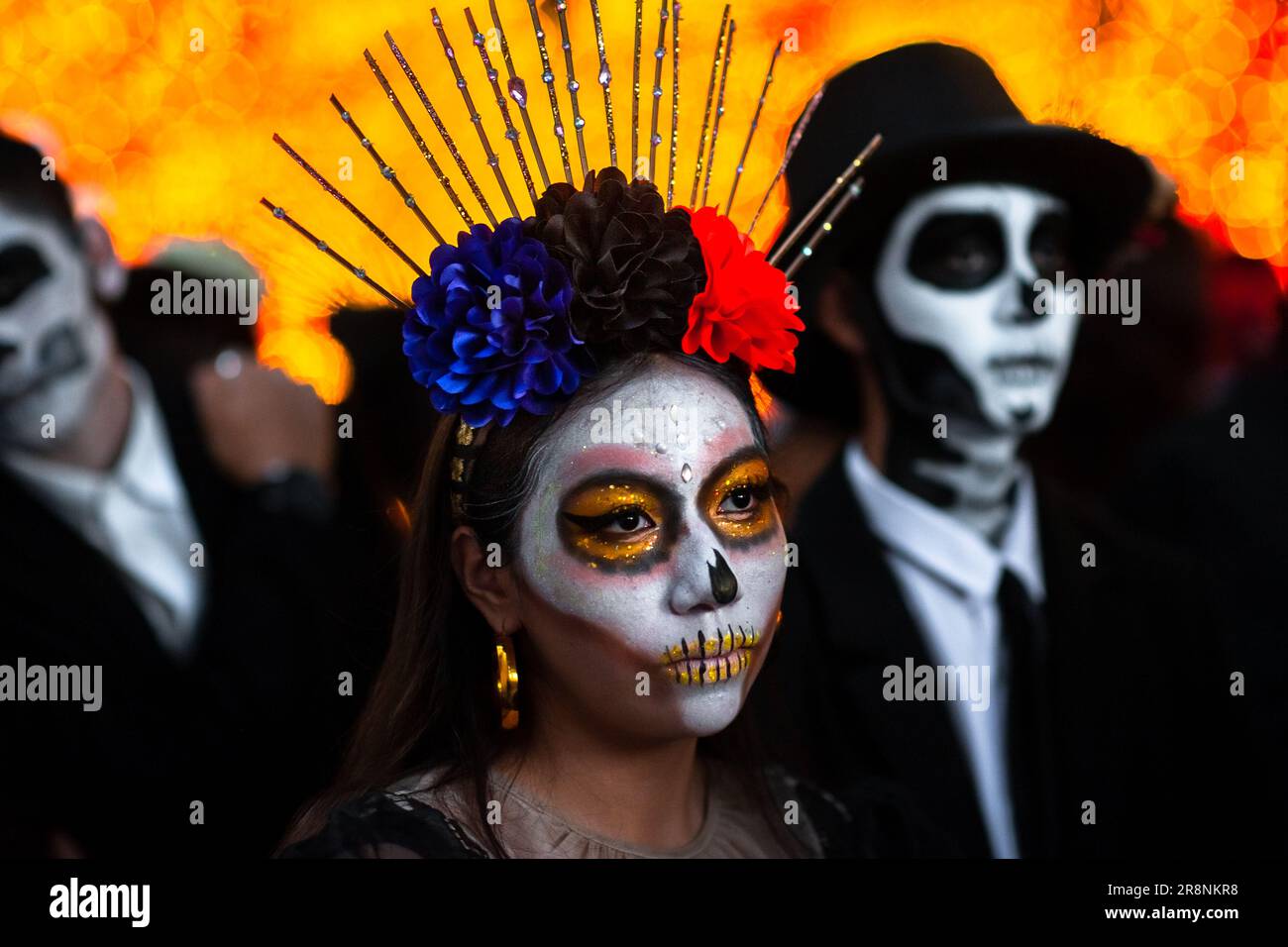 A Mexican woman, dressed as La Catrina, and Mexican men, dressed as Catrín, take part in the Day of the Dead festivities in Morelia, Mexico. Stock Photo