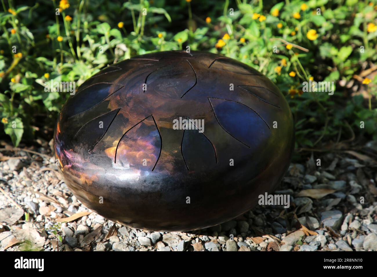 Steel tongue drum on ground outdoors. Percussion musical instrument ...