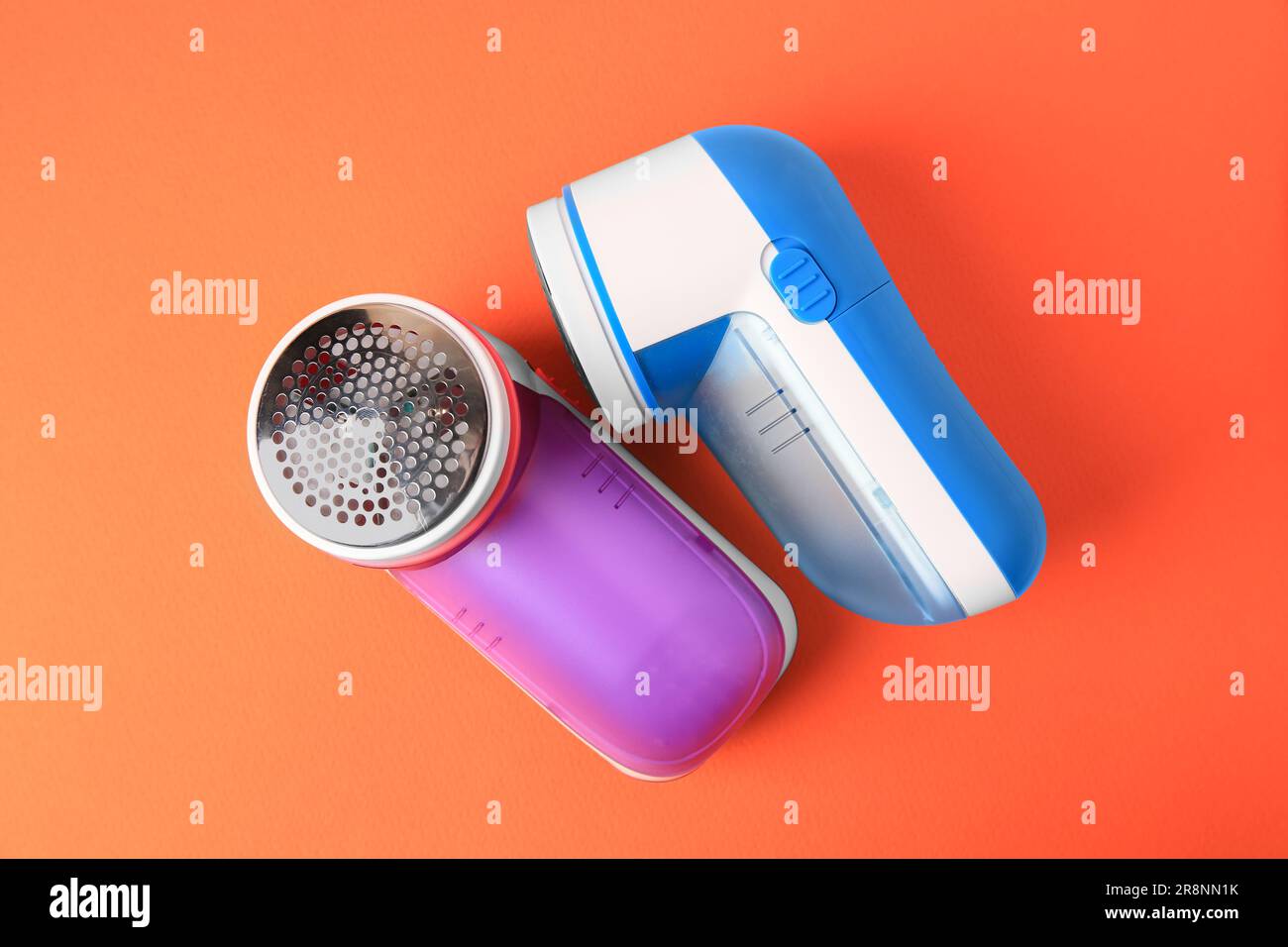 Different fabric shavers on orange background, top view Stock Photo