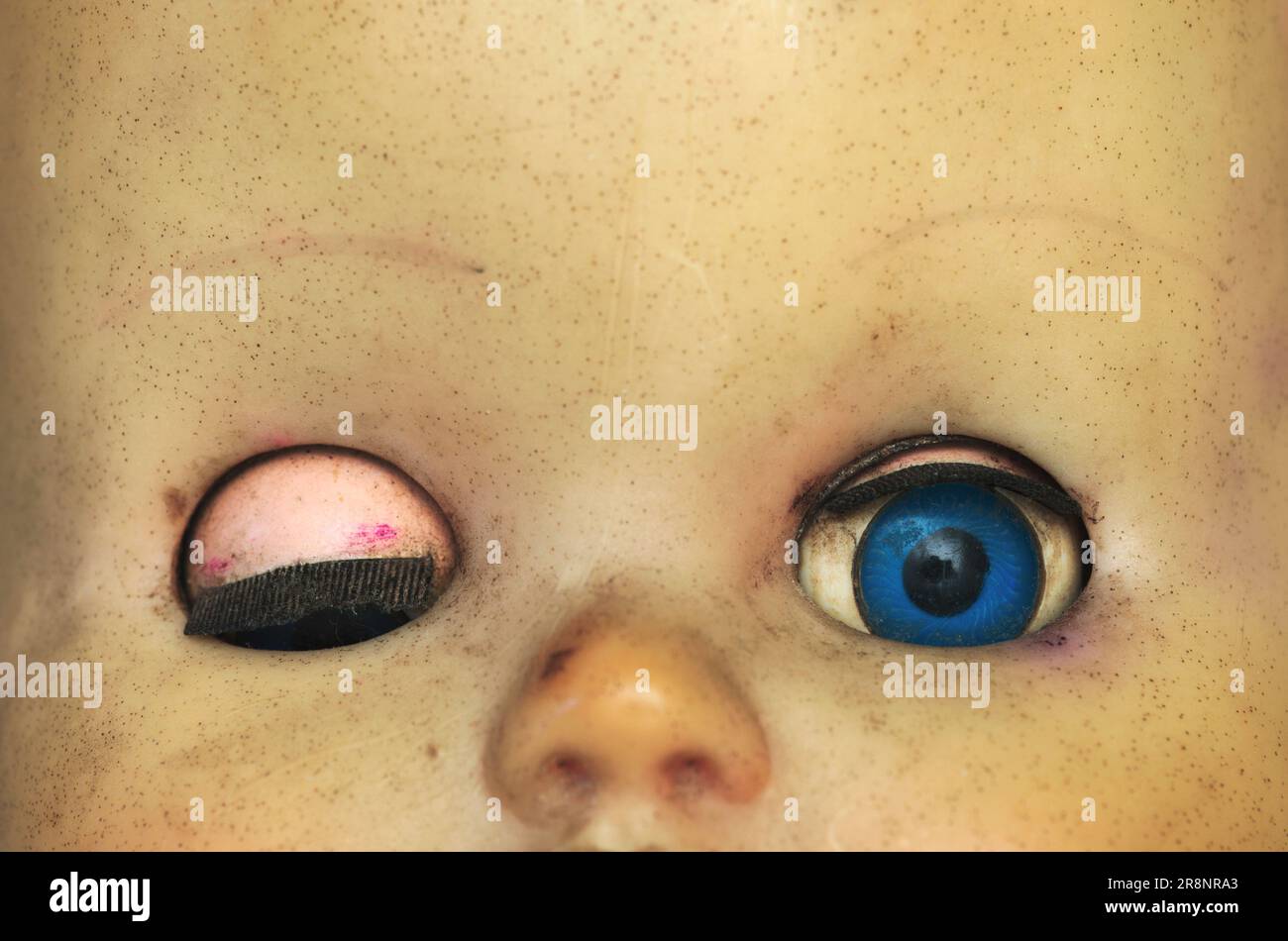 old baby doll doll with one eye closed and one eye opened Stock Photo
