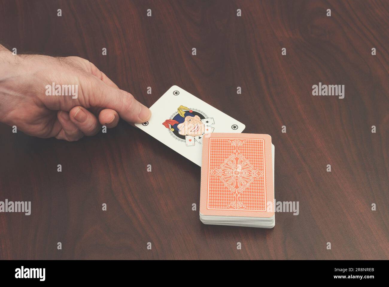 hand picking a joker card Stock Photo