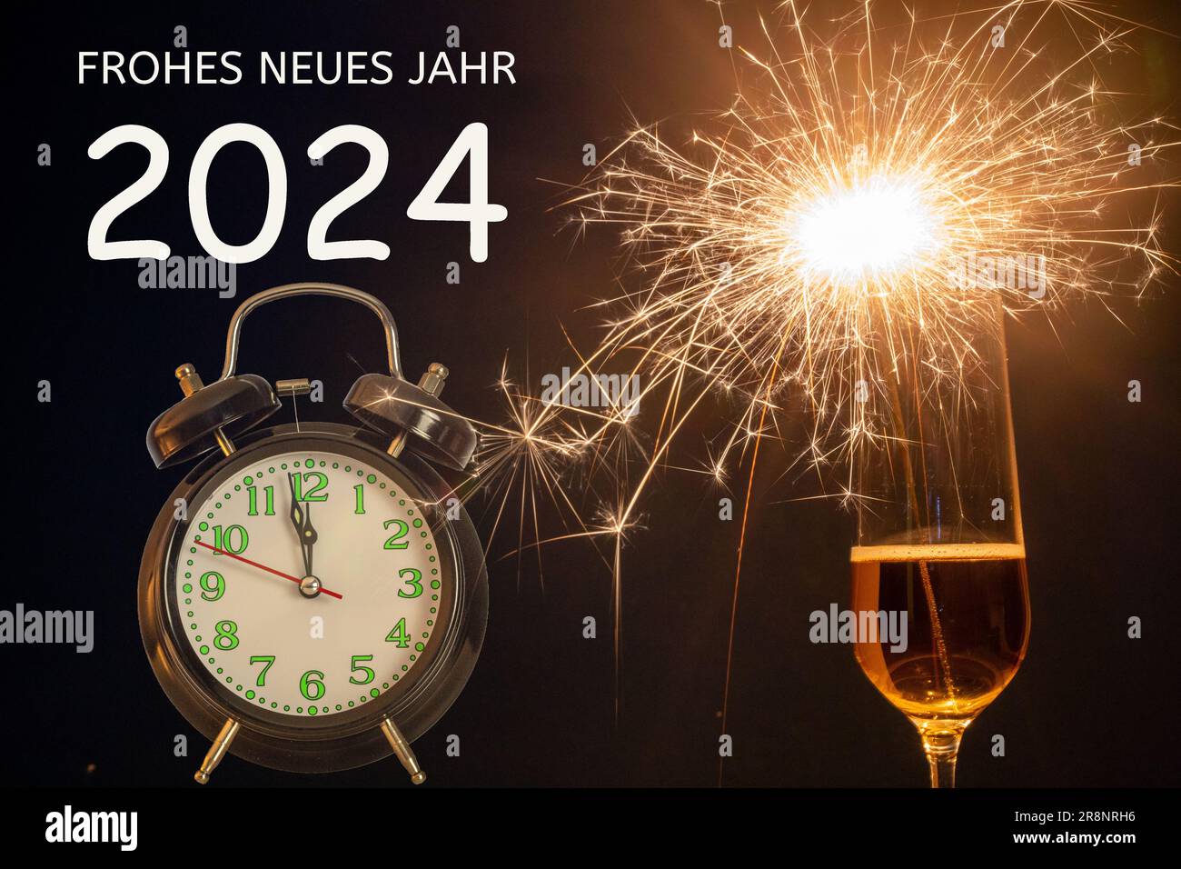 New Year's greetings Champagne glass with litsparklers next to a clock