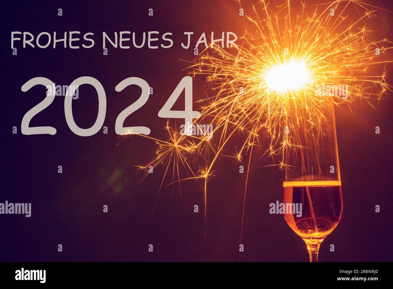 New Year's greetings: Champagne glass with lit sparklers and german 