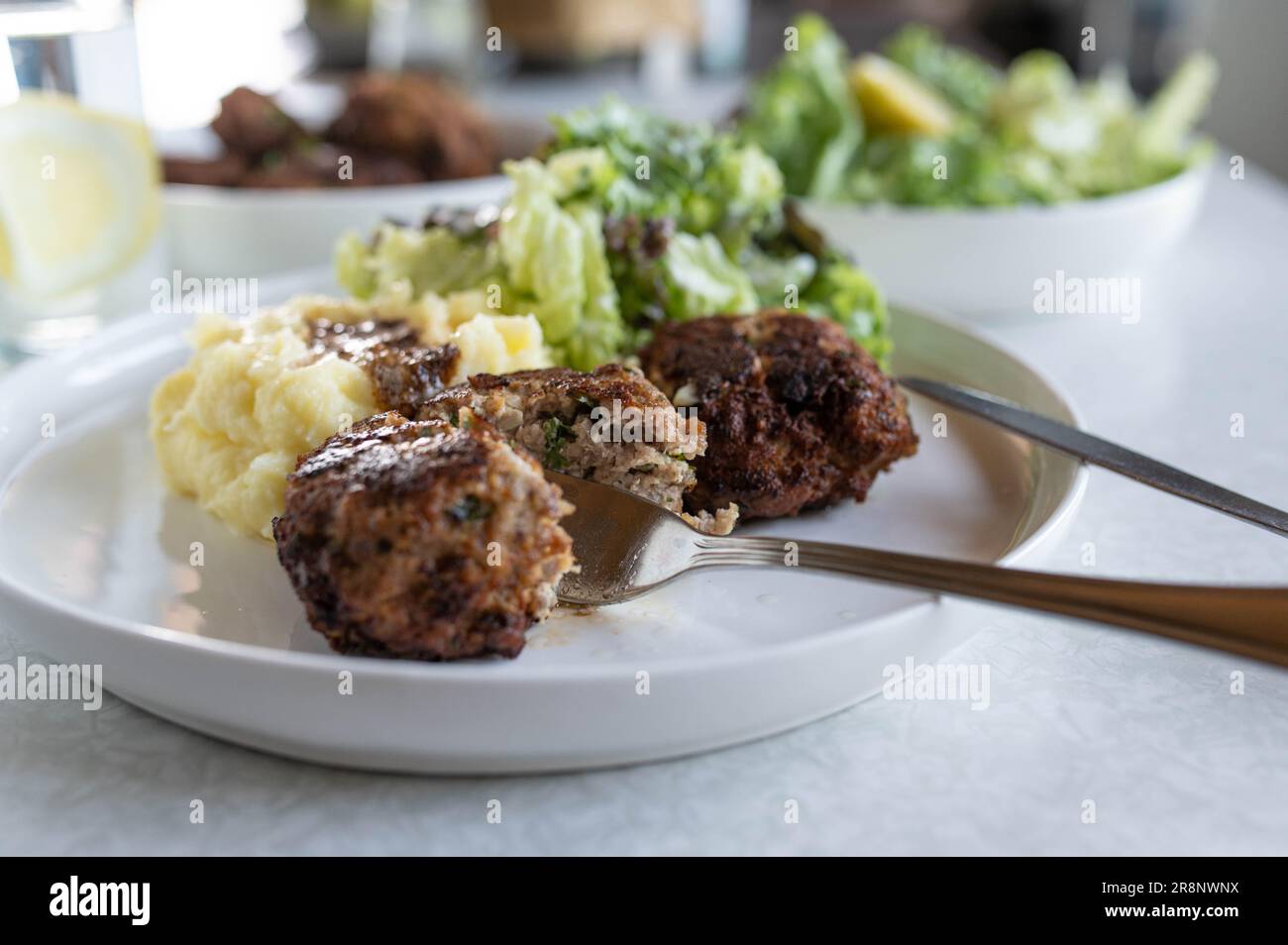 German meatballs with mashed potatoes and salad on a dinner table Stock Photo
