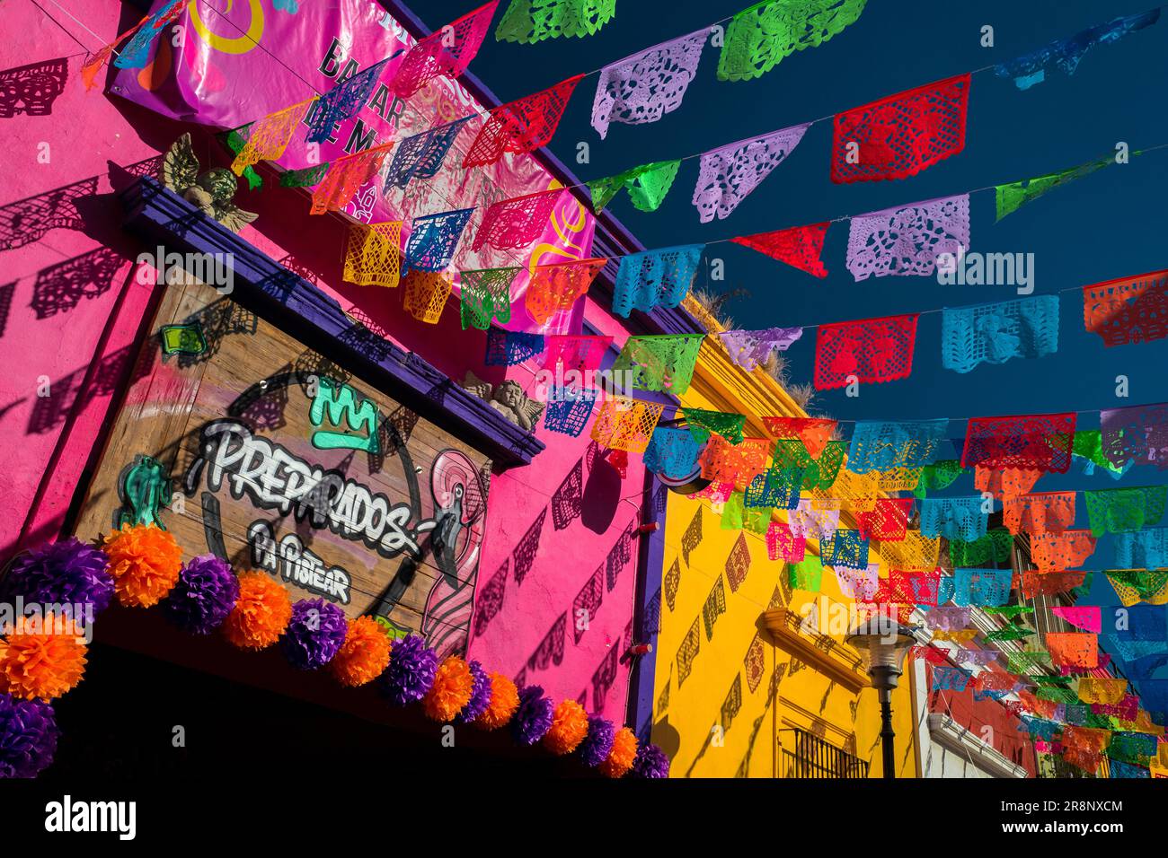 Pecked paper flags (papel picado) are seen attached to lines and hung above the street during the Day of the Dead festivities in Tlaquepaque, Mexico. Stock Photo