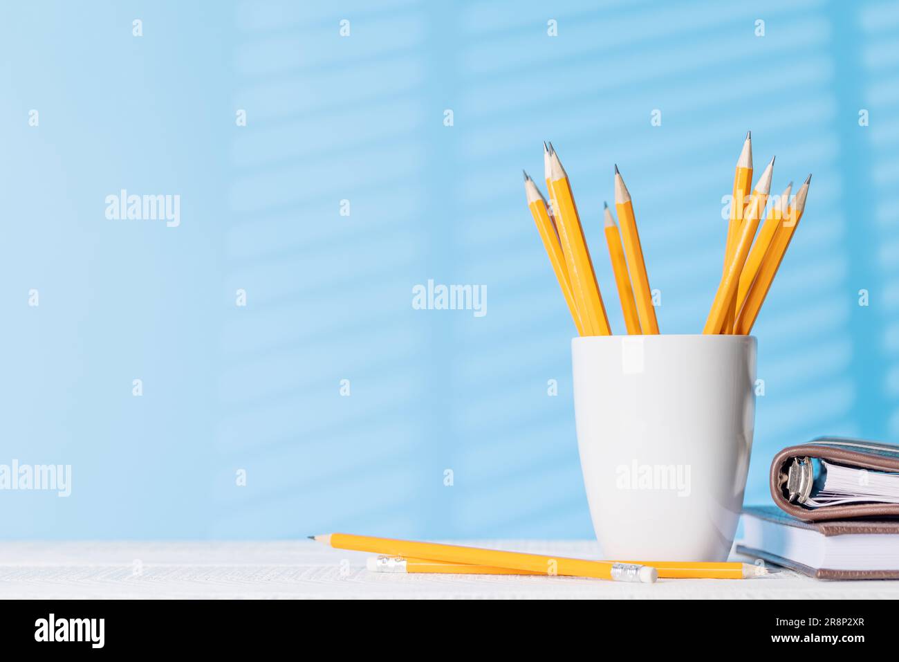 An organized arrangement of pencils and notepads on an office desk ...