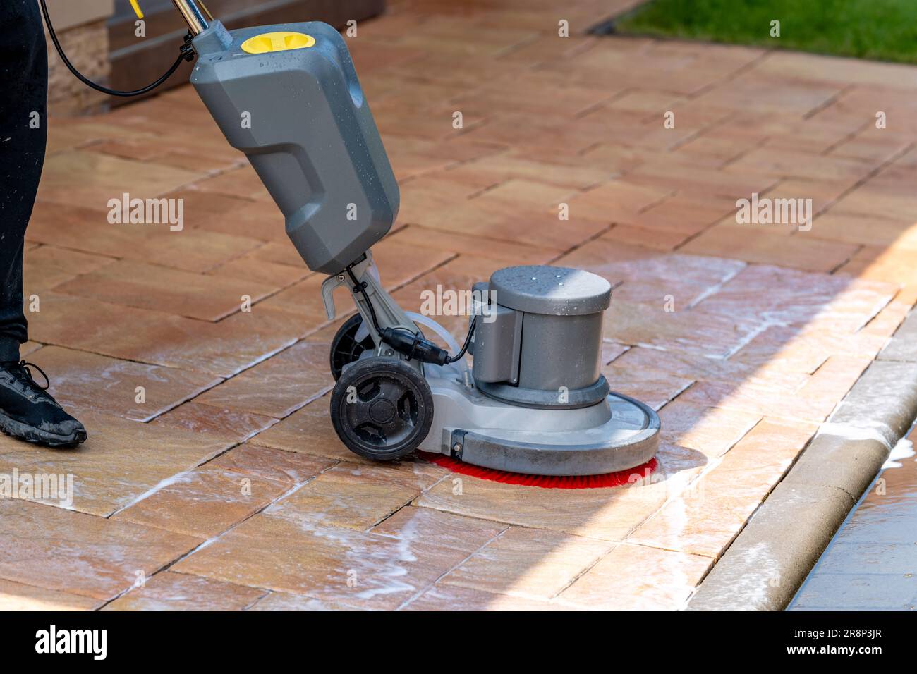 chemical machine cleaning concrete pavement in front of the house with a brush Stock Photo Alamy