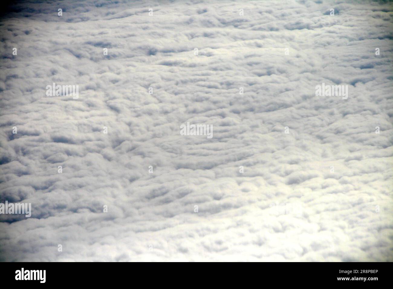 Aerial view of white, fluffy clouds against a light blue sky, seen ...