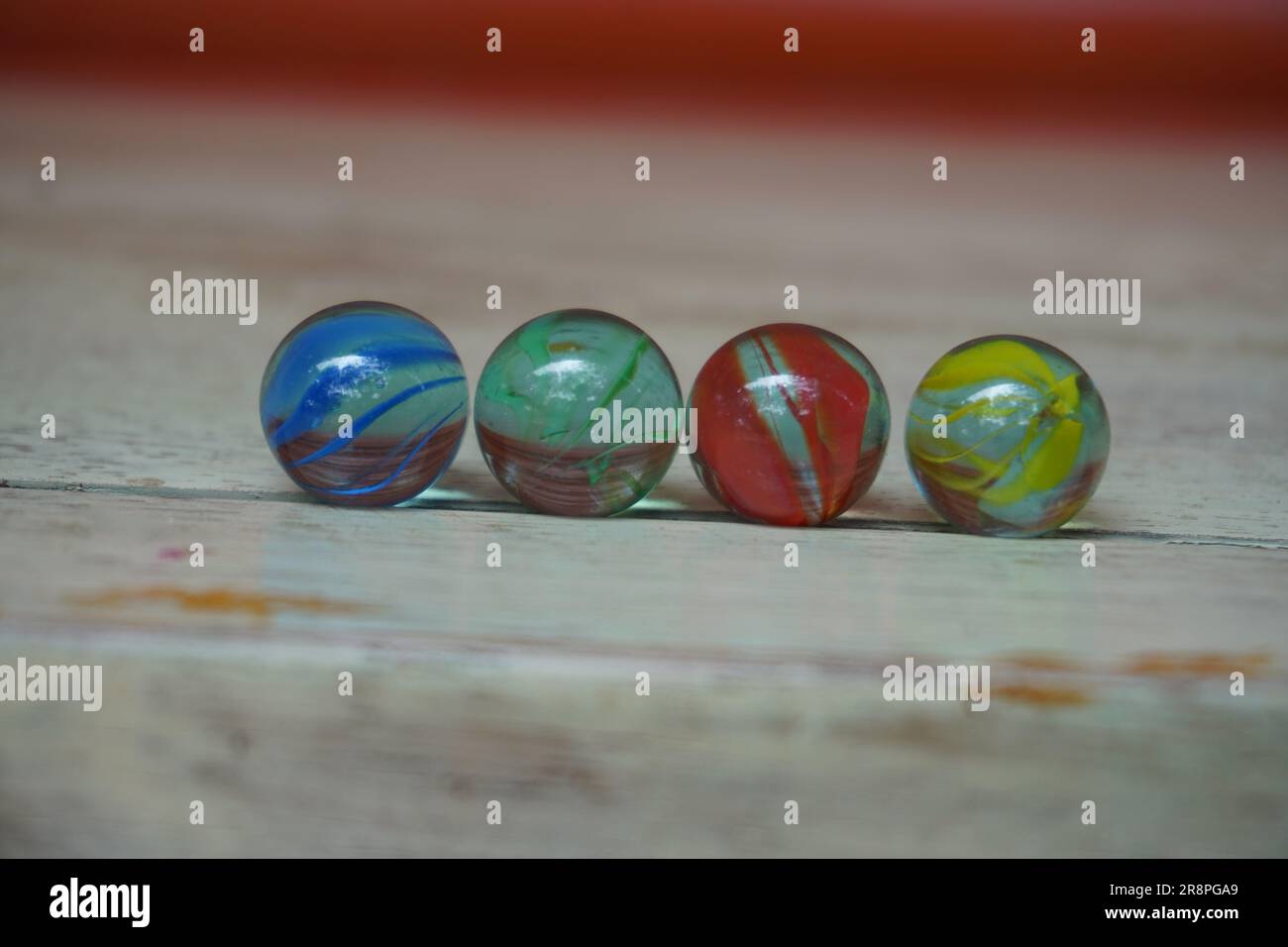 Four different colored marbles are arranged in a row Stock Photo Alamy