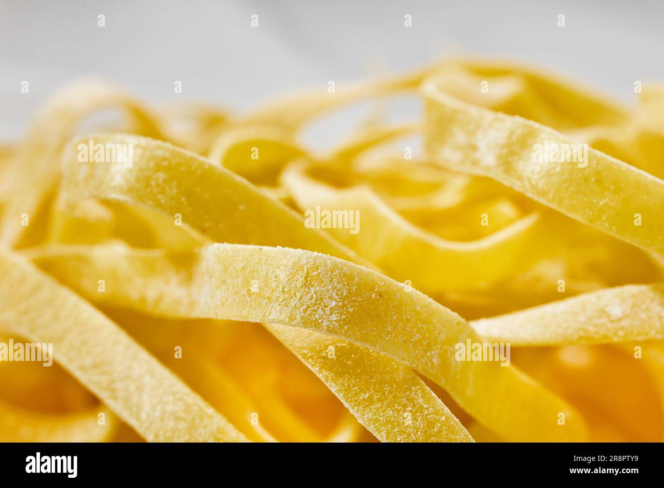 Yellow dried fettuccine , long flat pasta, healthy eating Stock Photo