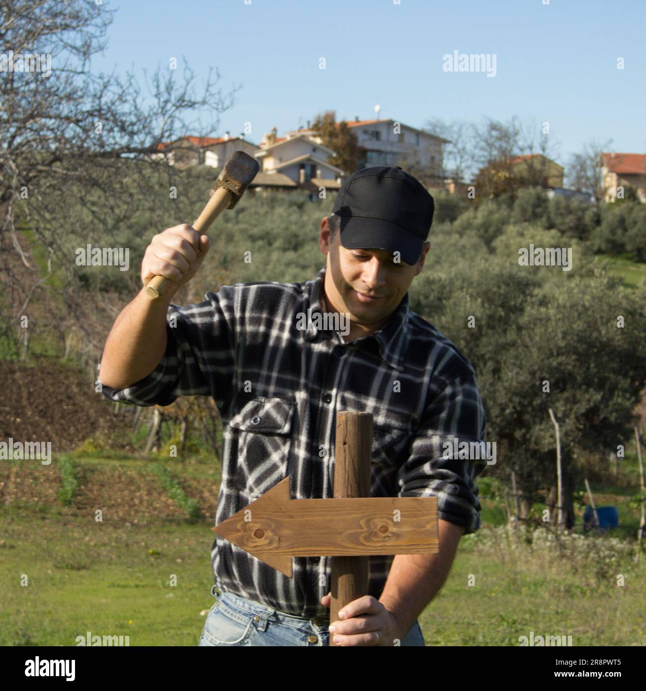 Image of a man driving a stake with an arrow into the ground with a