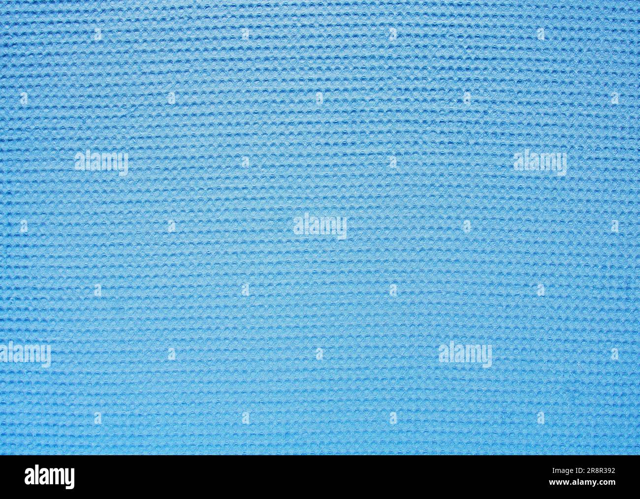 Abstract bright blue background from textured soft waffle fabric. Stock Photo