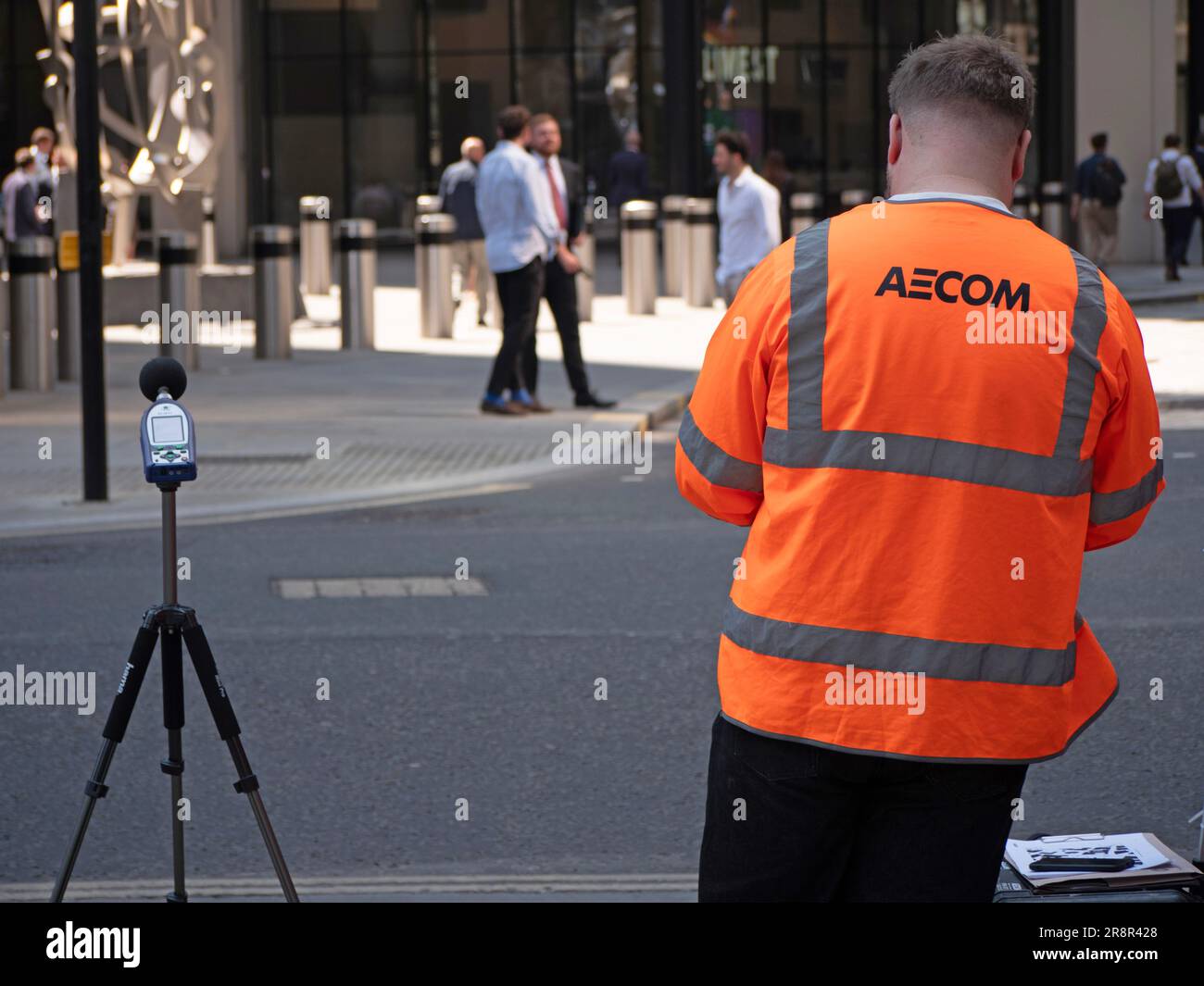 workman working for Aecom measuring sound in street with digital sound level meter, decibel meter,  on tripod. Stock Photo